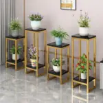Modern gold and black plant stands with decorative planters and indoor plants.