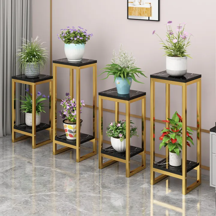 Modern gold and black plant stands with decorative planters and indoor plants.
