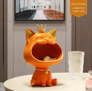 Orange cat figurine with crown on table, modern home decor accessory.