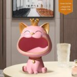 Pink crowned cat figurine on a table, modern home decor accessory.