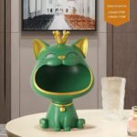 Green crown cat sculpture with gold accents on a table, modern home decor.