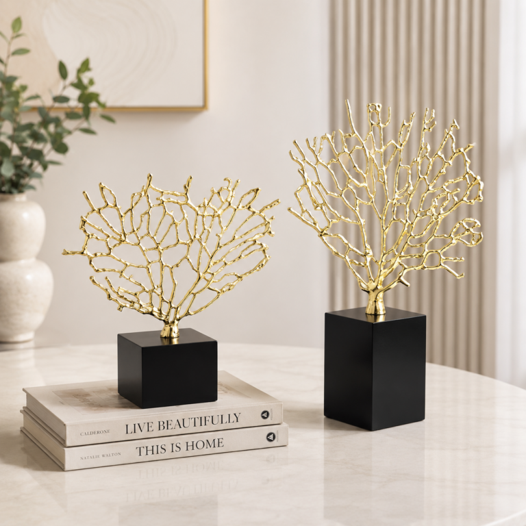 Gold coral sculptures on black bases, modern home decor on a marble table.