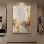 Modern luxury wall art in a living room, featuring abstract design with gold accents.