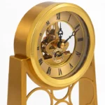 Close-up of a golden skeleton clock with intricate design, featuring Roman numerals and visible gears.