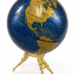 Glossy navy and gold globe with detailed map on a decorative gold stand.
