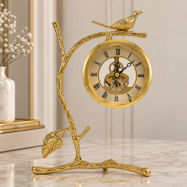Gold bird branch mantel clock on marble surface, modern luxury home decor.