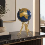 Luxurious blue and gold globe on ornate stand, modern home decor accessory.