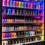 Neon-lit display cabinet with colorful vape products.