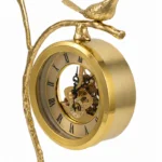 Ornate brass bird branch clock with Roman numerals, modern luxury home decor.