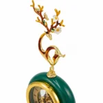 Ornate emerald clock with floral finial, luxury home decor accessory.