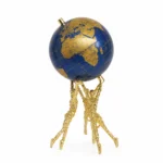 Sculptural gold stand with a blue and gold globe, modern home decor piece.